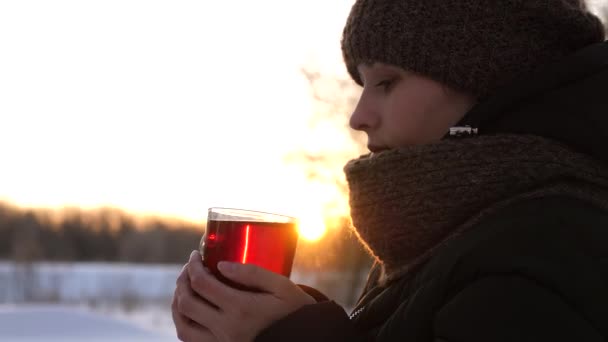 Mooi meisje permanent bij zonsondergang met warme mok thee en lachen. — Stockvideo