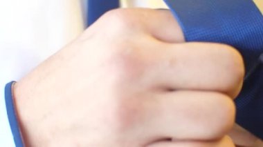 Erkek üzerinde mavi bir tieon beyaz bir gömlek koyar..