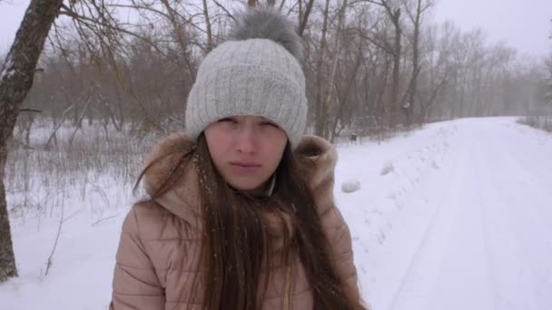 Серьёзная девушка в сильный снегопад, зимой. Slow Motion . — стоковое видео
