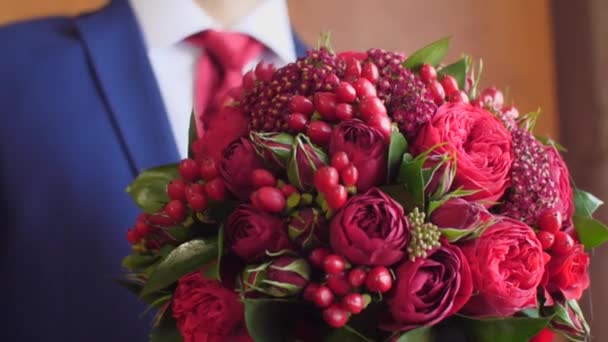 muž v saku a červená je krásná kytice z červených růží drží v ruce.