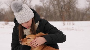 Güzel kız konturlar ve onu köpek kış park için üzülürken.