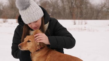 Güzel kız konturlar ve onu köpek kış park için üzülürken.