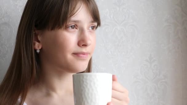 Mooie jonge vrouw dromen met een kop warme koffie. — Stockvideo