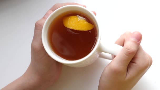 Slice of fragrant lemon in cup with zlotty tea in glass. — Stock Video