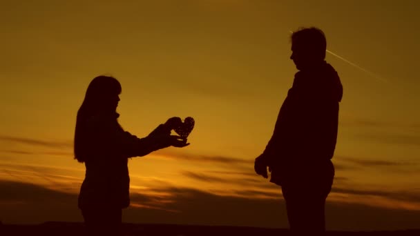 Dotter med pappa håller hjärtat i solnedgången, dotter ger hjärtat till pappa. — Stockvideo