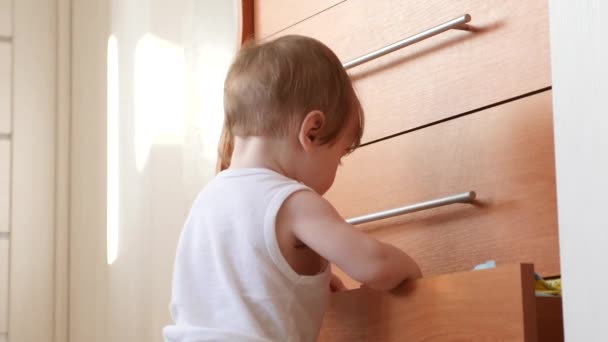 Kleine baby bederft, spelen in de kast en klimmen op dozen. — Stockvideo