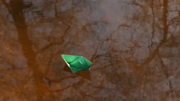 Barco de papel verde está flutuando na água . — Vídeo de Stock