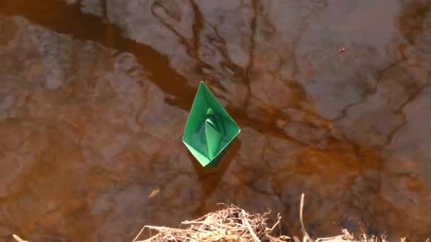 Barco de papel verde está flotando en el agua . — Vídeos de Stock