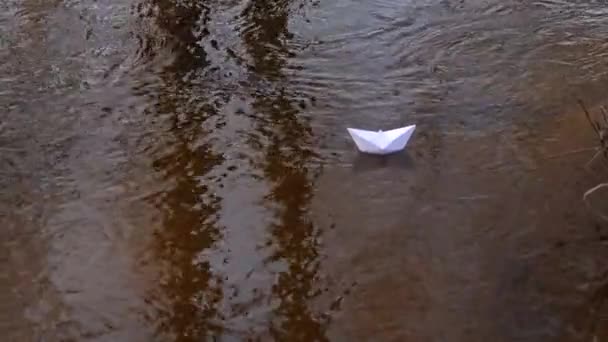 Pequeño barco de papel blanco fluye a lo largo del río . — Vídeos de Stock