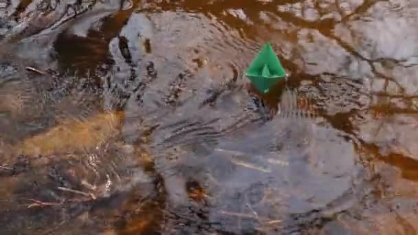 Pequeno barco de papel verde está fluindo ao longo do rio . — Vídeo de Stock