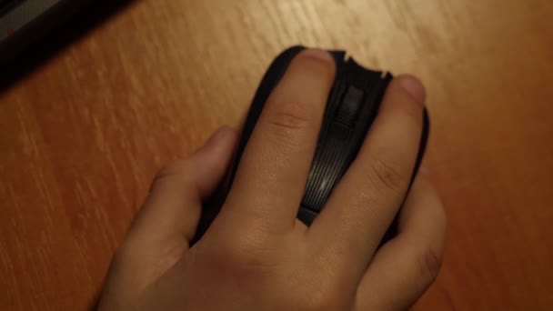 Gros plan de la main de l'enfant à l'aide d'un ordinateur de souris sur une table en bois . — Video