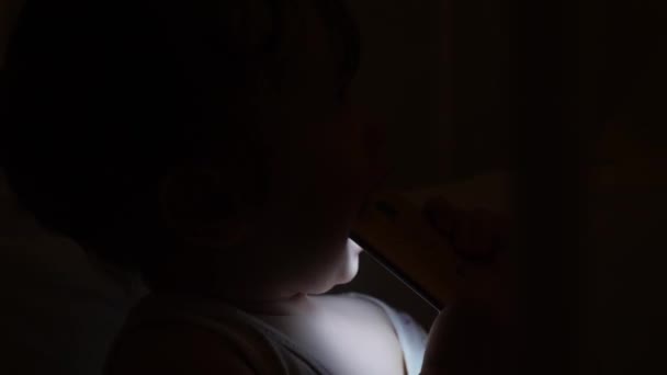 Enfant utilise tablette ou téléphone le soir ou la nuit avec la lumière du soir, le concept de e-learning, apprentissage et technologies simples.concept futuriste des enfants et des technologies appliquées . — Video