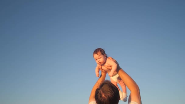 Pappa kastar baby i blå himmel. Slow motion. — Stockvideo