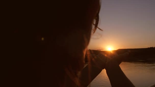 Girl is holding red sun at sunset. — Stock Video