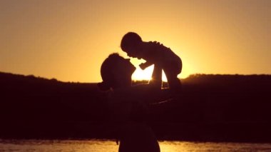 Anne bebek kırmızı günbatımı yukarıda atar. Ağır çekim.