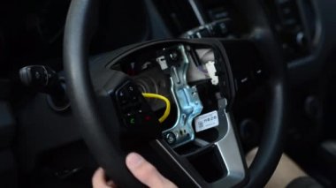 Erkek deri direksiyon simidi arabada onarıyor.