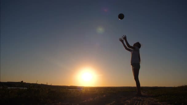 Adolescente jogando bola ao pôr-do-sol. Movimento lento . — Vídeo de Stock