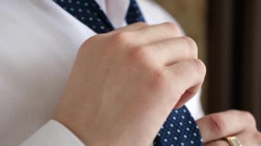 Erkek üzerinde mavi bir tieon beyaz bir gömlek koyar..