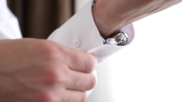 Człowiek, zapinane na guziki przycisk na białą koszulę. — Wideo stockowe