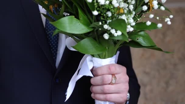 Красивий букет з різнокольорових квітів в руках чоловіків — стокове відео