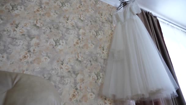 Gyönyörű fehér esküvői ruha lóg az ablakon fogas — Stock videók