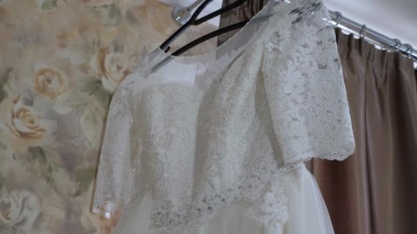 Vacker vit brudklänning hänger på galge på fönstret — Stockvideo