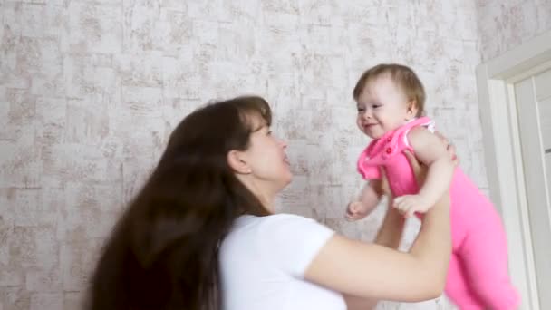 Moeder wendingen kind in zijn armen, de happy baby lacht — Stockvideo