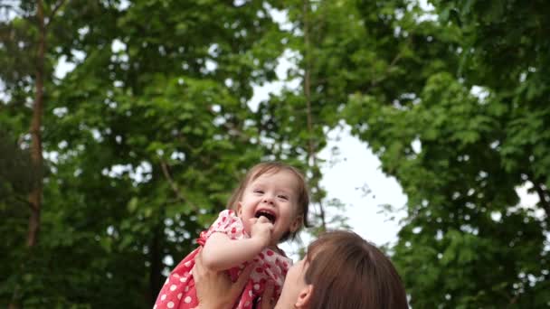 赤ちゃんは、愛情のあるお母さんの手を笑います。公園に散歩に一緒に遊んで、赤ちゃんとママが笑わせます。スローモーション. — ストック動画