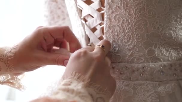Девушка одевается красивое белое платье для свадьбы — стоковое видео
