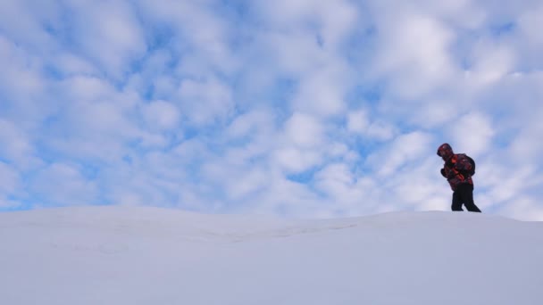 Команда альпинистов зимой поднимается на вершину горы. хорошо скоординированный командный туризм зимой. Путешественники следуют друг за другом вдоль снежного хребта . — стоковое видео