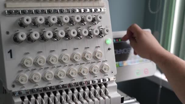 Egy munkás egy varrógépet programoz CNC-vel táblagéppel. Az üzemeltető beállítja a cnc gépet. — Stock videók