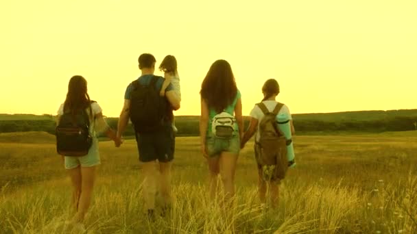 Viajeros de trabajo en equipo. Familia con niños viaja por las llanuras y montañas. padre lleva a una pequeña hija sobre sus hombros, una familia feliz viaja por el parque. padre, madre hija turistas . — Vídeo de stock