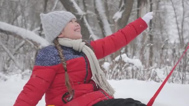 Ένα χαρούμενο κορίτσι κυλιέται στο Τούμπιγκ σε ένα λευκό χιονισμένο δρόμο και γελάει σε μια πτήση ελευθερίας. Χριστουγεννιάτικες διακοπές. Ένα διασκεδαστικό παιχνίδι για ενήλικες και παιδιά. Η έννοια της ευτυχισμένης οικογένειας — Αρχείο Βίντεο