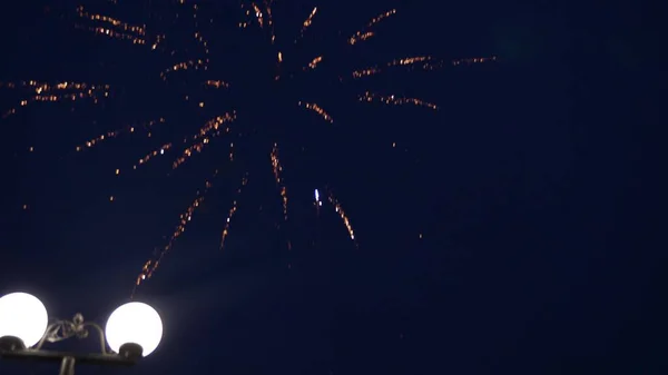 Leuchtendes Feuerwerk mit Bokeh-Lichtern am Nachthimmel. Glühendes Feuerwerk. Silvesterfeuerwerk. Ein buntes Feuerwerk am Nachthimmel. schöne farbige nächtliche Explosionen in schwarz — Stockfoto