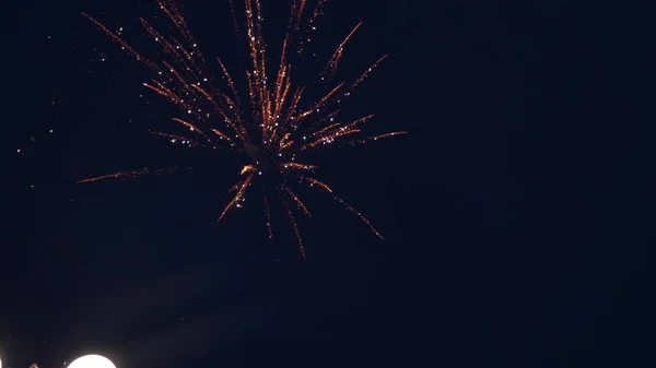 Leuchtendes Feuerwerk mit Bokeh-Lichtern am Nachthimmel. Glühendes Feuerwerk. Silvesterfeuerwerk. Ein buntes Feuerwerk am Nachthimmel. schöne farbige nächtliche Explosionen in schwarz — Stockfoto