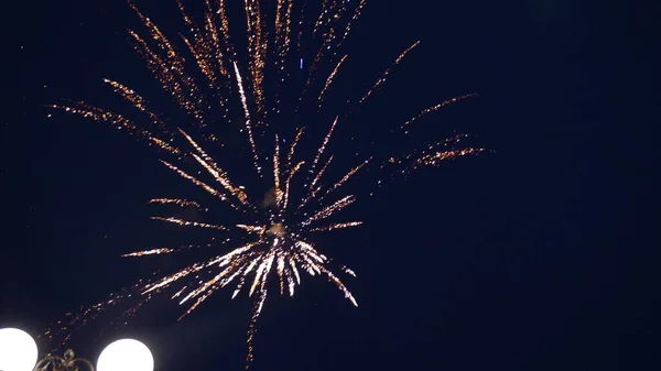 Leuchtendes Feuerwerk mit Bokeh-Lichtern am Nachthimmel. Glühendes Feuerwerk. Silvesterfeuerwerk. Ein buntes Feuerwerk am Nachthimmel. schöne farbige nächtliche Explosionen in schwarz — Stockfoto