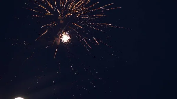 Leuchtendes Feuerwerk mit Bokeh-Lichtern am Nachthimmel. Glühendes Feuerwerk. Silvesterfeuerwerk. Ein buntes Feuerwerk am Nachthimmel. schöne farbige nächtliche Explosionen in schwarz — Stockfoto