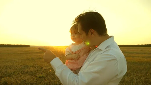 幸福家庭和童年的概念。 父亲和女儿们在公园里玩耍。 日落时，爸爸妈妈抱着一个小女儿玩耍。 日落时一家人带着孩子散步. — 图库照片
