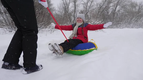 Niño y madre en trineo en la nieve. Hija y mamá juegan en el parque de invierno en las vacaciones de Navidad. vacaciones de invierno familiares. concepto de infancia feliz — Foto de Stock