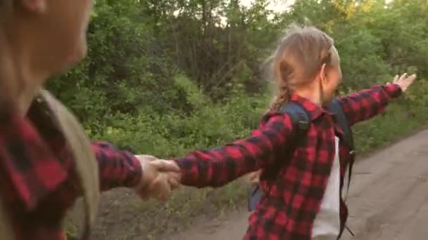 子供旅行者バックパック付きの女の子旅行者は明るい太陽の光の下で手を握って田舎道を走っていますハイカーガール。10代の女の子が旅をして手を握って私についてきて — ストック動画