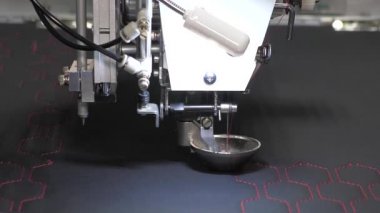 Otomatik makine nakış işi. CNC 'li robotlar üretim hattında çalışıyor. Robot dikiş makinesi. Bilgisayar dikiş makinesini kontrol eder. otomatik dikiş makinesi. yakın plan