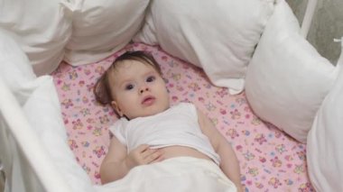 küçük çocuk beşiği yatıyor ve dönen oyuncaklara görünüyor.