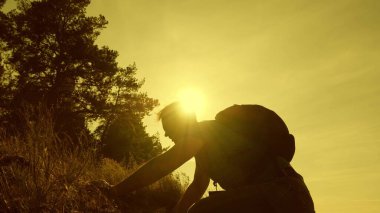 Baba, dağa tırmanmaya yardım eden çocuklara yardım elini uzattı. Günbatımında çocukları olan turist ailesi. Baba, sırt çantalı çocuklar seyahat eder. turist takım çalışması