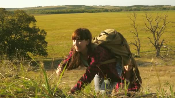 Dzieci podróżujący z plecakami pomagają sobie nawzajem wspiąć się na wzgórze. Backpackerzy pomagają sobie wspiąć się na wzgórze. Rodzina turystów z dziećmi podróżującymi o zachodzie słońca. Praca zespołowa dla turystów. Zwolniony ruch — Wideo stockowe