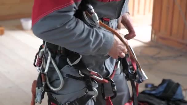 Przemysłowy alpinista zakłada sprzęt do pracy na dużej wysokości. w sprawie karabinków taśmowych wspinaczy. — Wideo stockowe