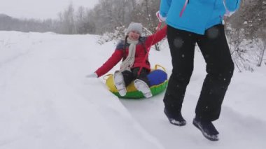 Mutlu çocukluk kavramı. Aile kış tatili. Çocuk ve anne karda kayıyorlar. Kız ve anne Noel tatillerinde kış parkında oynuyorlar..