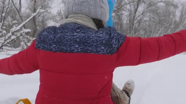 快乐童年的概念。 家庭寒假。 孩子和母亲在雪中滑行。 3.圣诞佳节，女儿和妈妈在公园里玩耍. — 图库视频影像