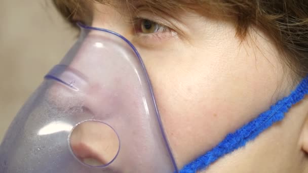 Köhögés elleni kezelés. Közelkép. Egy álarcos beteg nőt lélegeznek be. egy lány kék kórházi maszkban. Hörghurut inhalációs gőzkezelése. — Stock videók