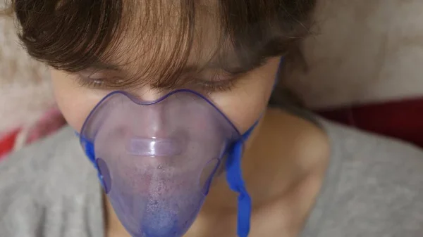 Femme est traitée avec un masque d'inhalation sur son visage dans un hôpital. fille malade est inhalé par un nébuliseur assis sur le canapé. femme masquée. Inspirez des vapeurs pour les voies respiratoires dans les poumons. Traitement de la toux — Photo