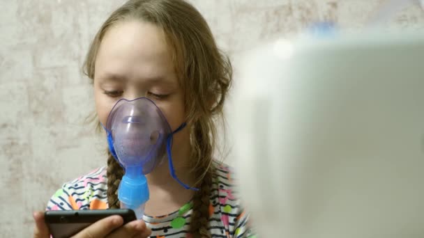 Criança com comprimido está doente e respira através de um inalador. close-up. menina tratada com uma máscara inalatória em seu rosto no hospital. A criança trata a gripe inalando vapor inalatório . — Vídeo de Stock